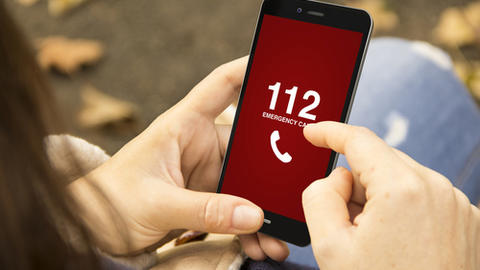 Frau wählt am Handy den Notruf 112