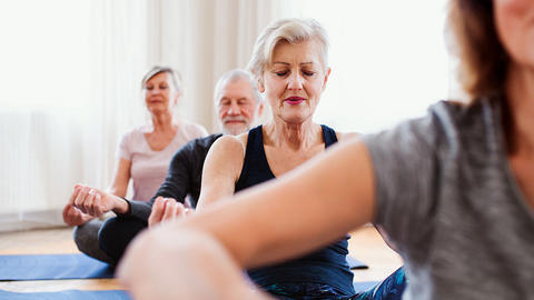 Gruppe von Menschen die Yoga machen und sich entspannen