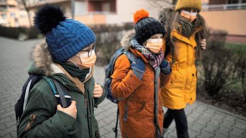 Kinder tragen auf dem Schulweg Masken