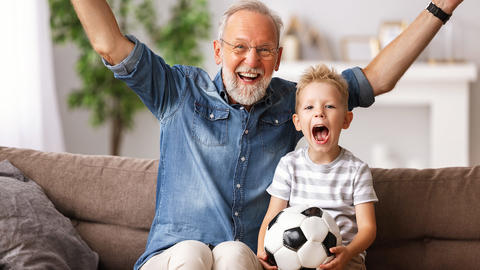 Opa und Enkel schauen gemeinsam Fußball