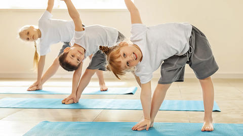 Mehrere Kinder, die Yoga machen