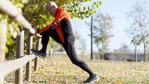 sportlicher Herr dehnt sich im Park