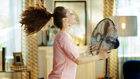 Frau sucht abkühlung am ventilator 